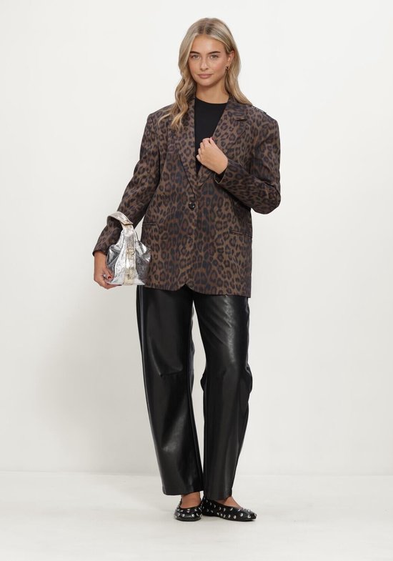 Model in bruine luipaardblazer, zwarte broek, zwarte top en zilveren handtas, volledig figuur.