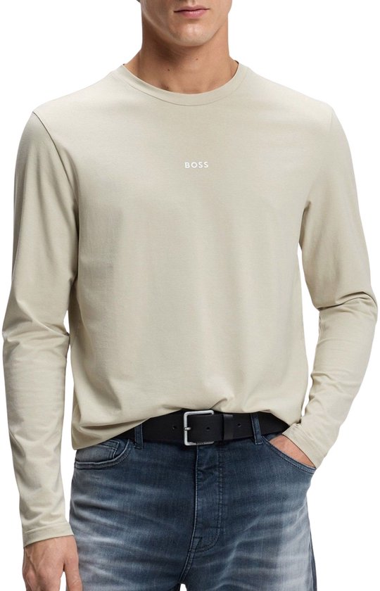 Model draagt een beige shirt met lange mouwen en klein wit BOSS-logo op de borst, gecombineerd met een zwarte riem.