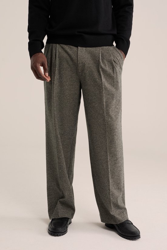 Loose fit broek in grijze wol-look met dubbele bandplooien en zwarte instapschoenen.