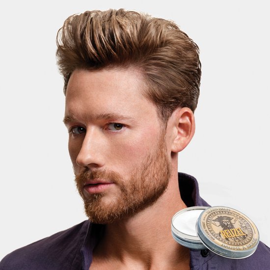 Man met lichtbruin haar en verzorgde baard, naast een blikje Reuzel baardbalsem.