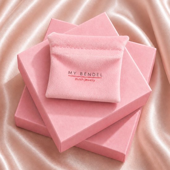 Roze fluwelen zakje met My Bendel logo bovenop drie roze geschenkdozen op een satijnen ondergrond.