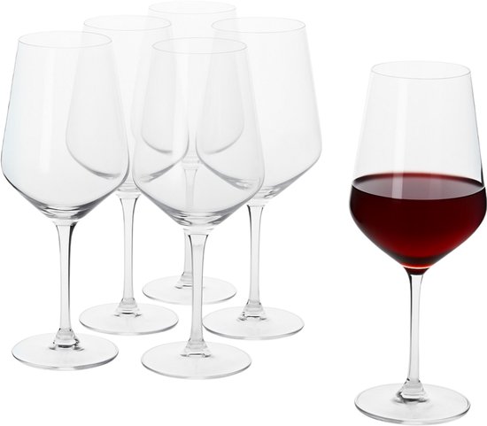 Set de 5 verres à vin vides à côté d'un verre à vin rempli de vin rouge.