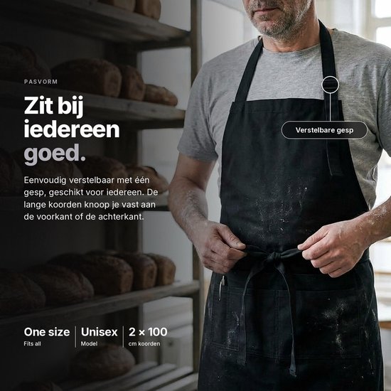 Een man met een zwart schort in een bakkerij. Het schort heeft lange koorden en een verstelbare gesp.