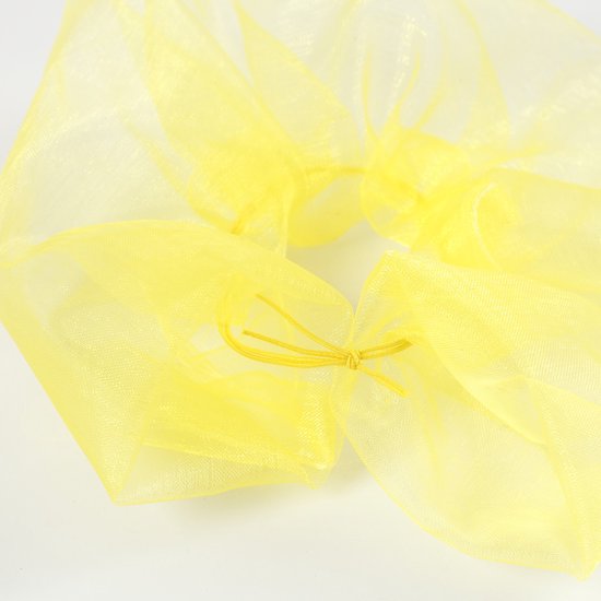 Rimpelige scrunchie van doorschijnende gele organzastof.
