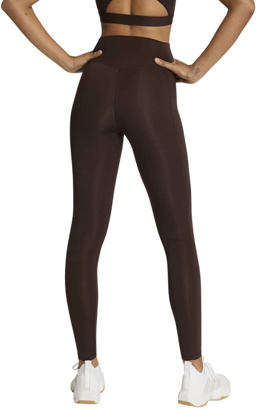 Achteraanzicht van een bruine sportlegging met hoge taille op model.