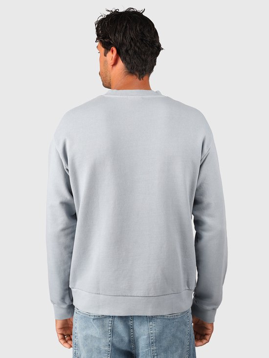 Achterkant van een lichtblauwe Brunotti sweater gedragen met een jeans.