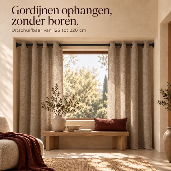 Gordijnen aan een zwarte roede boven een raam. Tekst: Gordijnen ophangen, zonder boren. Uitschuifbaar 125-220 cm.