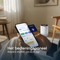 Smartphone met app voor luchtreiniger in de hand. Op de achtergrond een witte luchtreiniger.