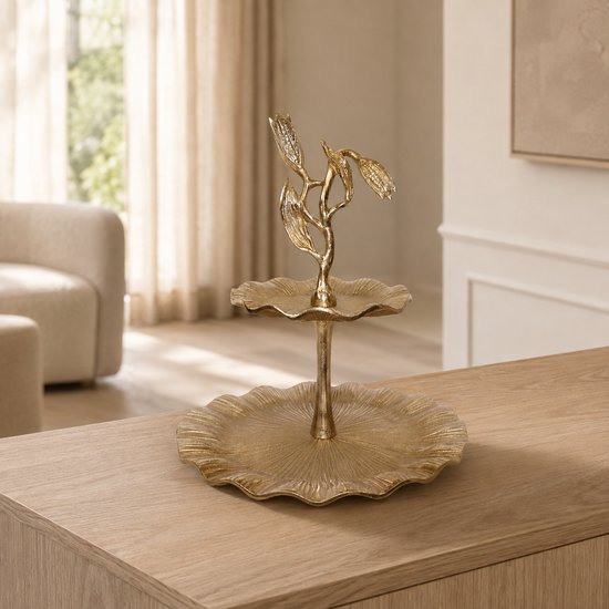 Goudkleurige 2-laagse etagère met bloemmotief op een houten tafel in een licht interieur.