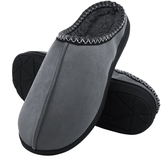 Paar grijze suède pantoffels met donkergrijze pluche voering en zwarte antislipzool.