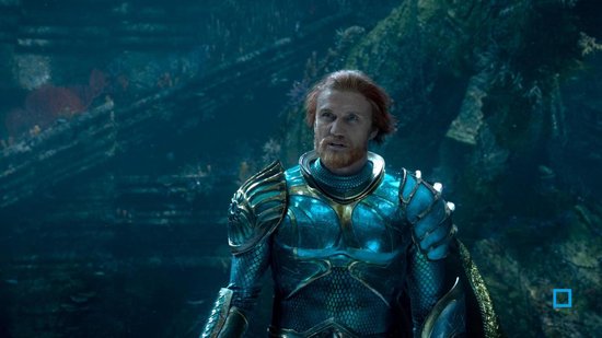 Man met rood haar en baard, draagt een turquoise harnas. Hij kijkt naar een man met donker haar.