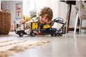 Jongen speelt met LEGO Technic Volvo FMX truck en gele graafmachine.