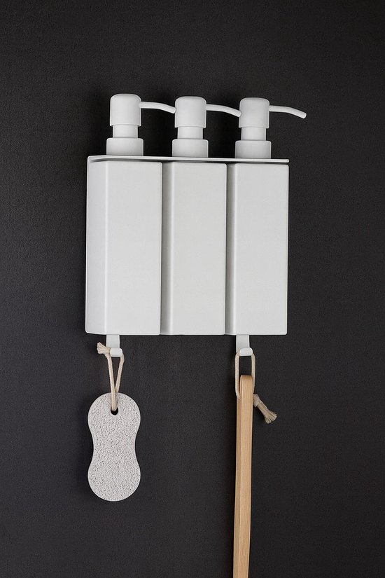 Drie witte zeepdispensers met een zeespons en houten borstel eraan.