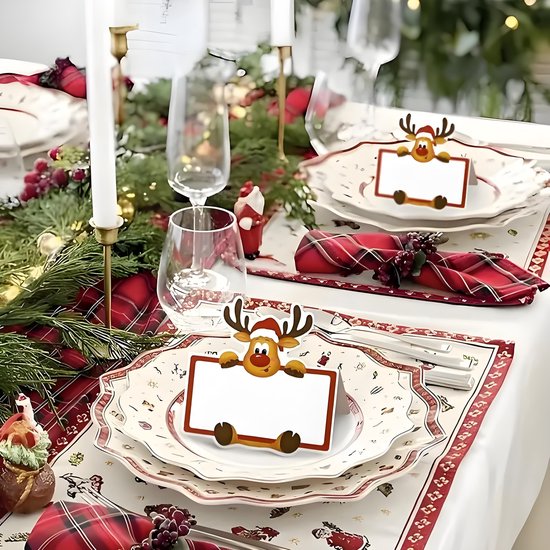 Kersttafel gedecoreerd met rendier naamkaartjes op de borden, servetten met ruitpatroon en denneboomtakken.