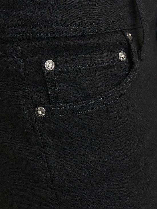 Detail van een zwarte jeans met klinknagels en stiksels op de voorzak.