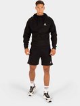 Man met spierbundel met een zwarte trainingsjas en korte broek van Gorilla Wear.