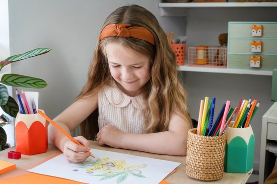 Meisje met oranje hoofdband kleurt met oranje Bic Kids potlood een tekening van een jaguar.