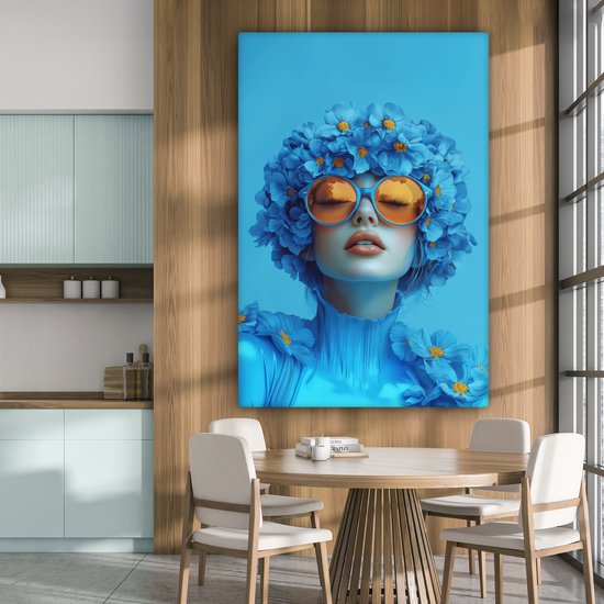 Portrait bleu d'une femme avec des lunettes orange et des fleurs, dans une salle à manger avec un mur en bois.