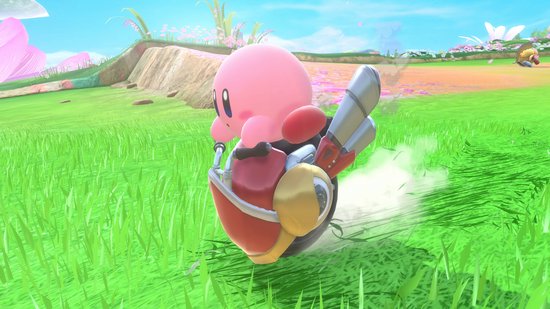 Kirby met raket-aandrijving op een rood en geel voertuig, vliegend door groen gras.
