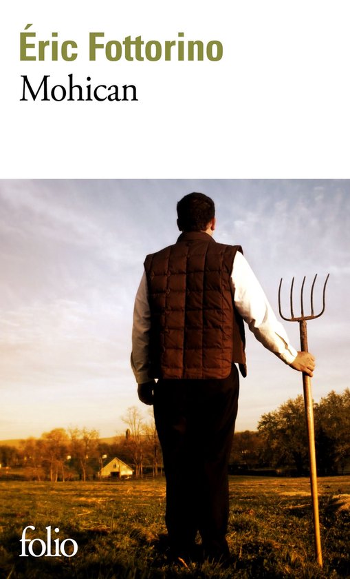 Homme tenant une fourche, debout dans un champ, portant un gilet marron et une chemise blanche.