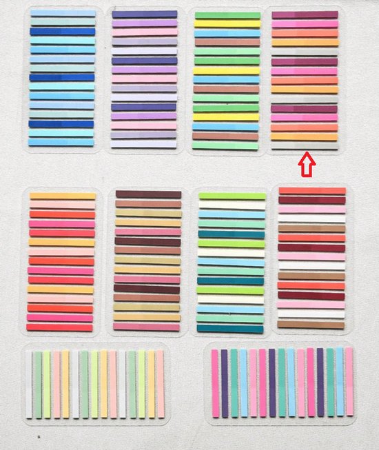 Plaattoon van acht boekjes met vrolijk gekleurde, gestreepte indexstickers in rijen, zoals roze, oranje, geel, blauw en groen.