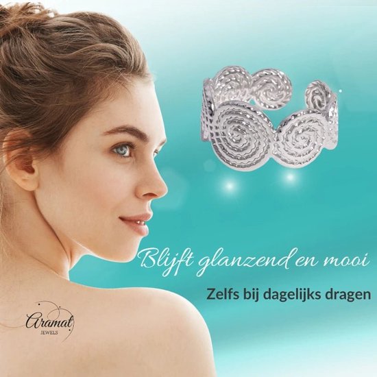 Zilverkleurige stalen damesring met gedraaide cirkelmotieven, gedragen op een model.
