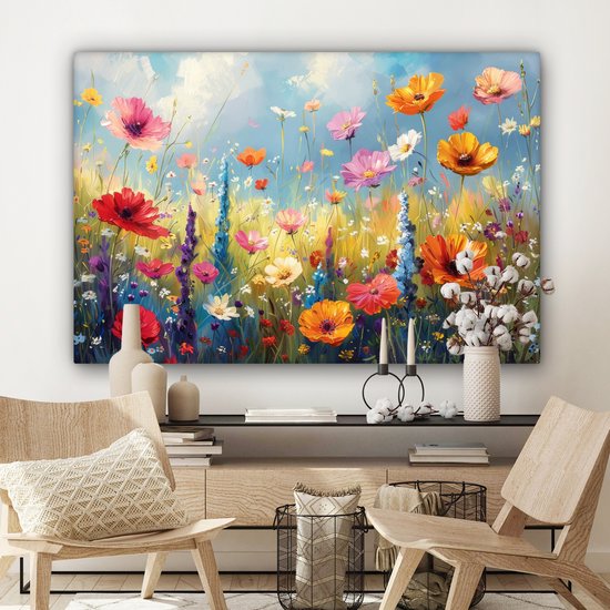 Une peinture d'un champ de fleurs avec des fleurs rouges, oranges et roses au-dessus d'un buffet avec des objets décoratifs et deux chaises en bois.