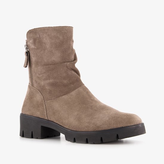 Beige suède enkellaars met rits aan de zijkant en een dikke hak.