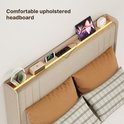 Een detail van het beige gestoffeerde hoofdbord met opbergruimte, verlichting, tablet, telefoon en koptelefoon.