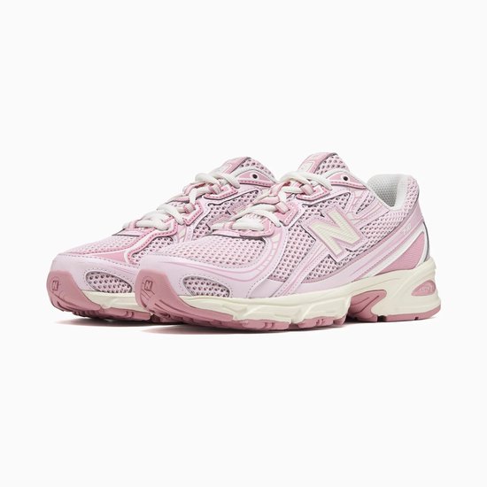 Lichtroze New Balance sneakers met beige en roze details, witte N-logo's en witte veters.