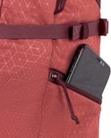 Rode rugzak met geometrisch patroon en een zijvak met rits waarin een smartphone zit.