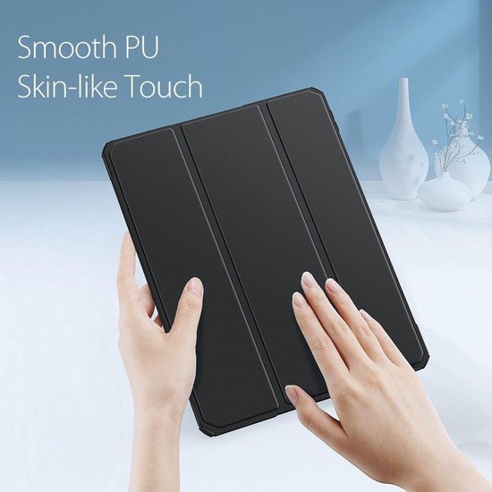 Handen die een zwarte, gladde tablet hoes met textuur vasthouden.
