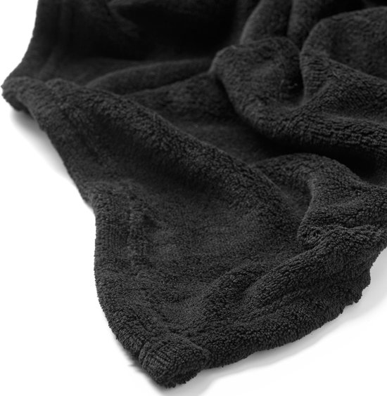 Close-up van de zachte textuur van een zwarte fleece plaid.