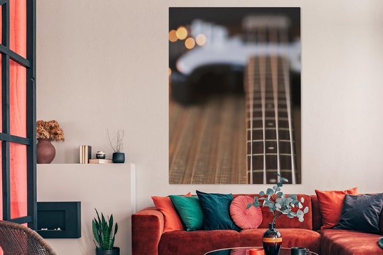 Une guitare basse repose sur le sol Toile 120x160 cm - Tirage photo sur toile (Décoration murale salon / chambre) XXL / Groot format!
