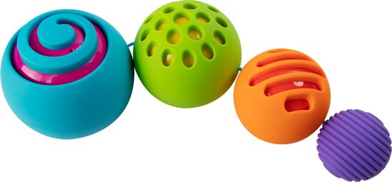 Een rij van vier speelgoedballetjes: blauw met roze spiraal, groen met gaten, oranje met spleten, paars geribbeld.