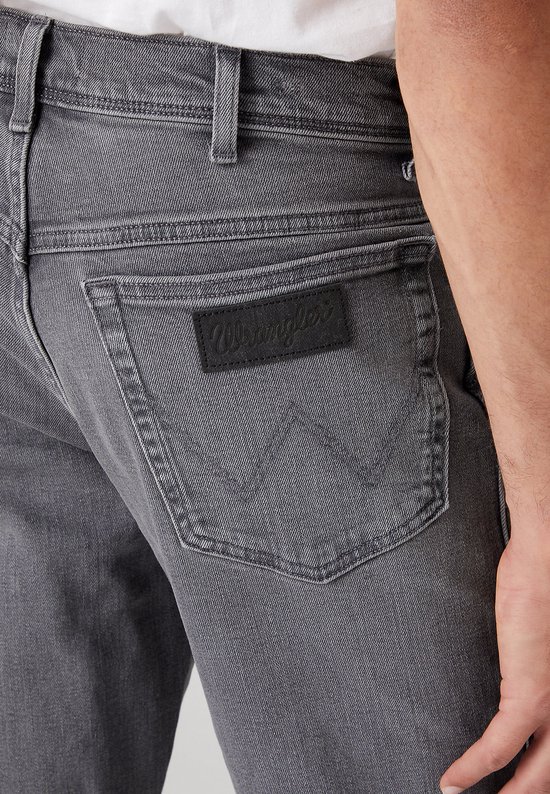 Donkergrijze jeans met zwarte Wrangler-logopatch op de achterzak.
