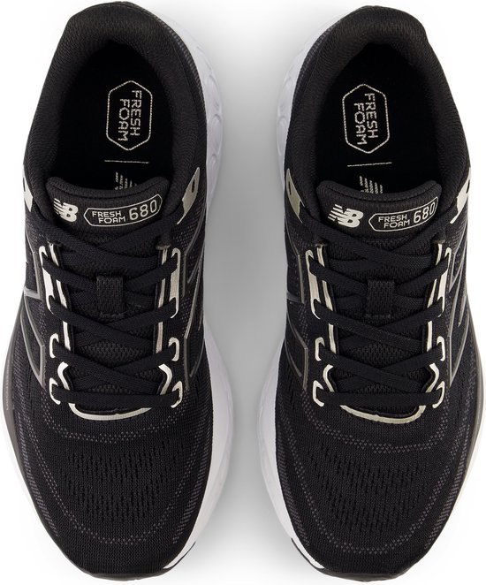 Bovenkant van zwarte New Balance sportschoenen, met witte veters, 'Fresh Foam' en '680' opdruk.