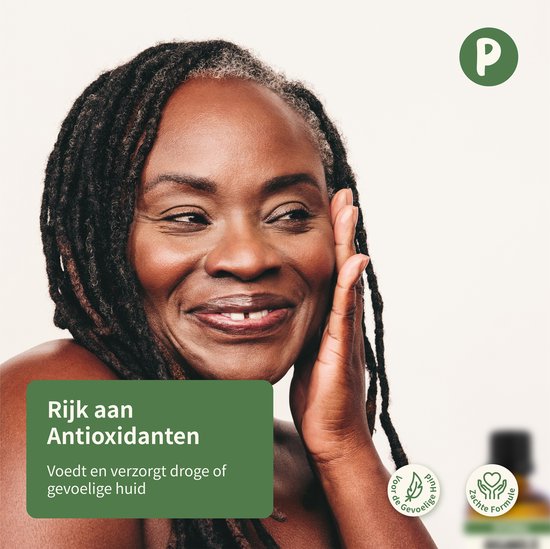 Zwarte vrouw met dreadlocks glimlacht en raakt haar gezicht aan.