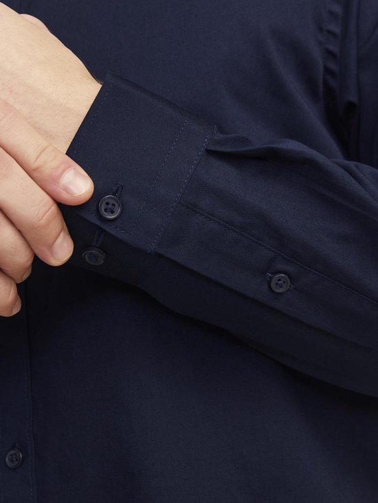 Sluiting van een marineblauw overhemd, detail van knopen op de manchet.
