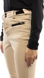 Detail van een beige skibroek met zwarte ritssluiting op de zak en zwarte mouwen.