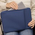 Donkerblauwe laptoptas met rits en voorvak. Een laptop wordt erin geschoven.