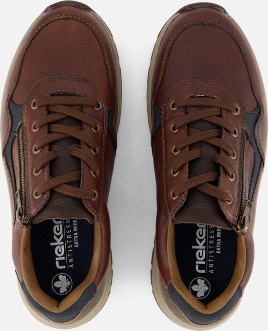 Bovenkant van een paar bruine leren sneakers met veters en ritssluiting. Riekers logo op de binnenzolen.