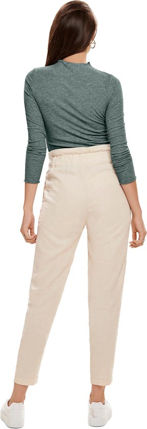 Model van achteren gezien, effen groene top met rolkraag en beige broek.