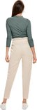 Model van achteren gezien, effen groene top met rolkraag en beige broek.