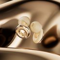 Twee gouden Loop Switch oordopjes met beige siliconen tips op een glanzende gouden achtergrond.