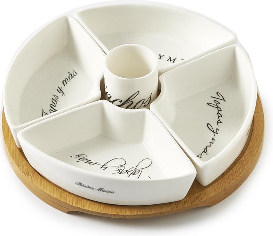 Wit tapasplateau met 4 vakken en een middenbakje, op een houten schijf. De vakken bevatten tekst zoals 'Tapas y más'.