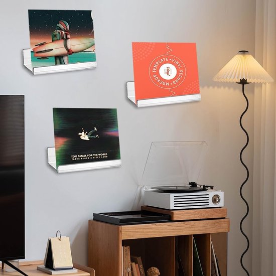Drie acryl planken met elk een vinylhoes, een met een robot, een met een cirkelontwerp, en een met twee figuren.