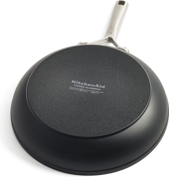 Onderkant van een zwarte KitchenAid-koekenpan met 'Forged Aluminium' en symbolen voor vaatwasser en inductie.