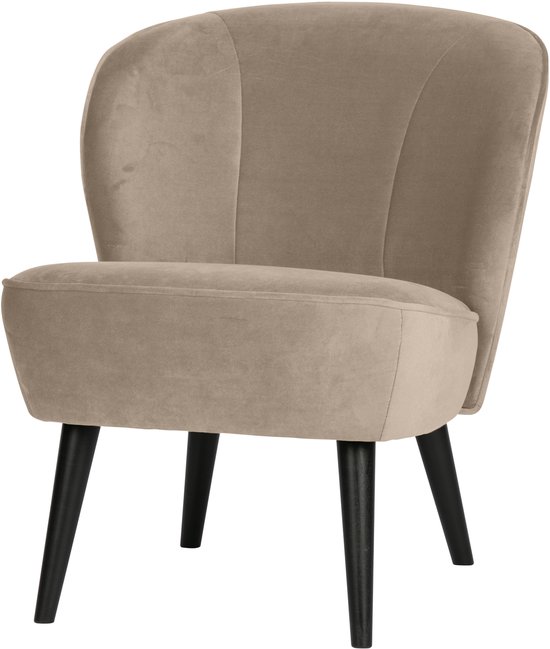 Beige fluwelen fauteuil met gebogen rugleuning en zwarte poten, van voren gezien.