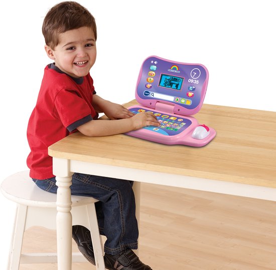 Jongetje met een rode trui en spijkerbroek speelt met een roze VTech Game & Leer Laptop.